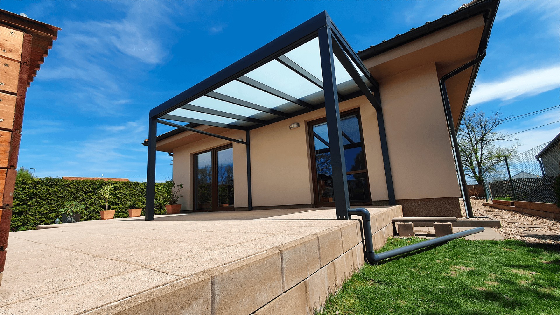 Moderní antracitová hliníková pergola se zasklenou střechou na terase rodinného domu