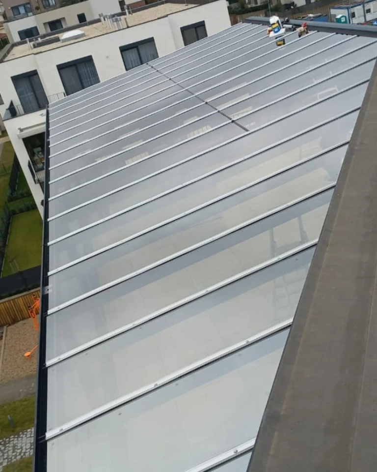 Pohled shora na prosklenou střechu hliníkové pergoly na terase