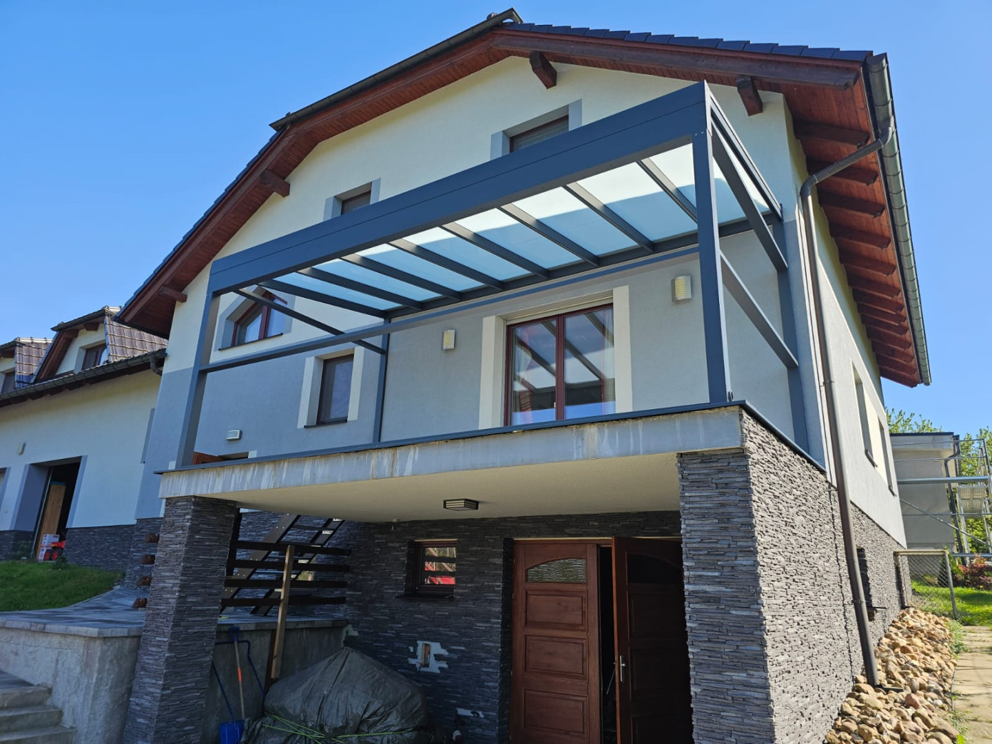 Moderní hliníková pergola se skleněnou střechou namontovaná na balkóně rodinného domu