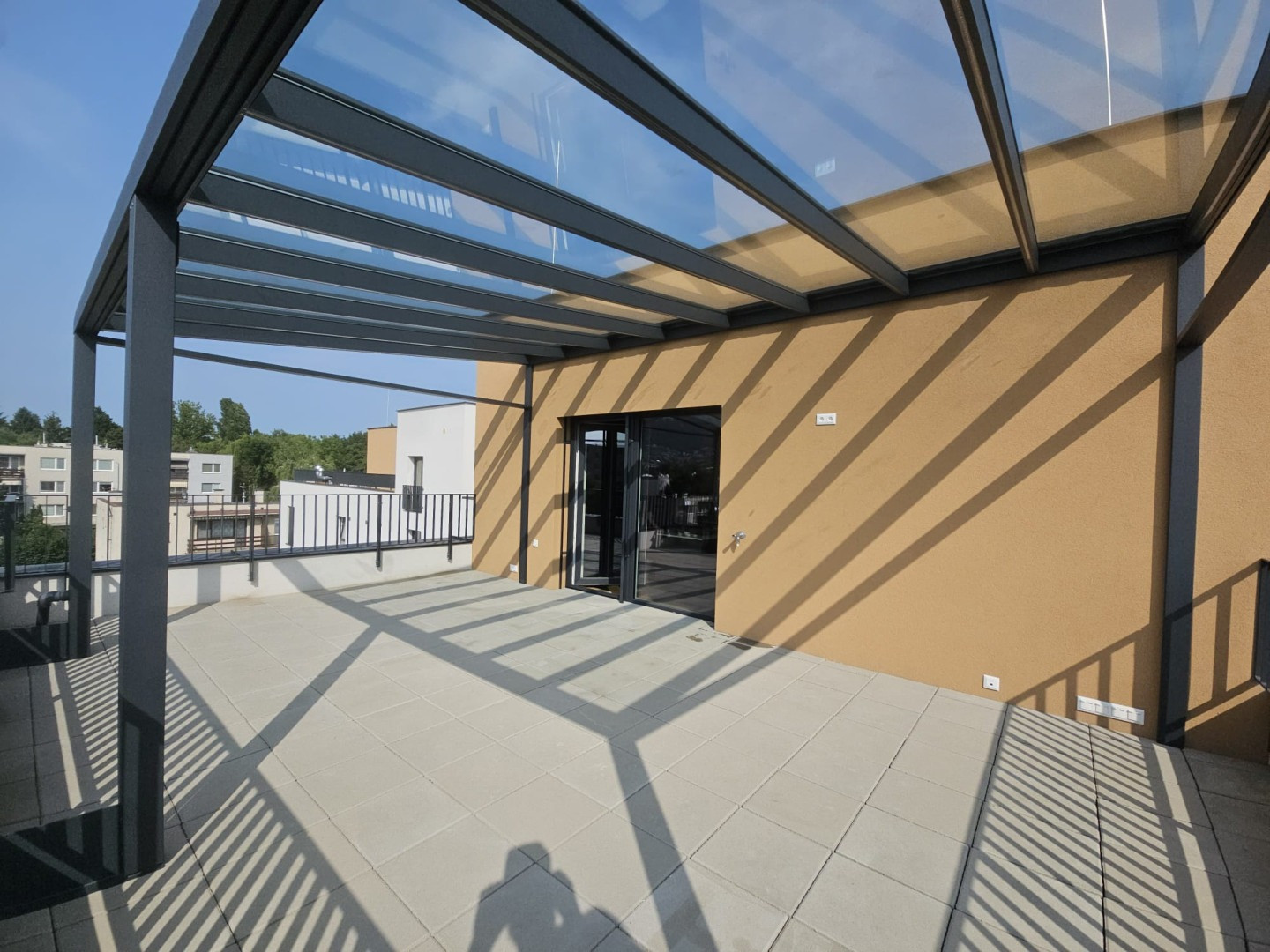 Moderní hliníková pergola se zasklenou střechou na terase bytového domu