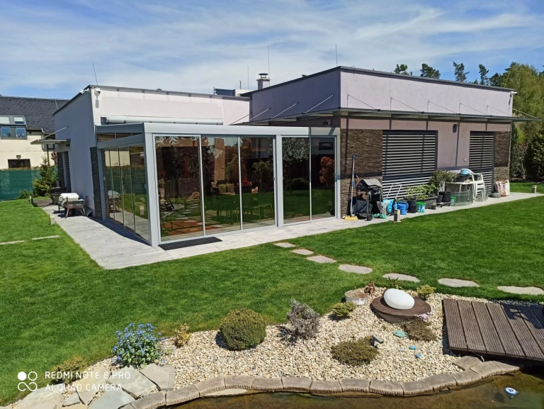 Moderní hliníková pergola se zasklením v zahradě u rodinného domu