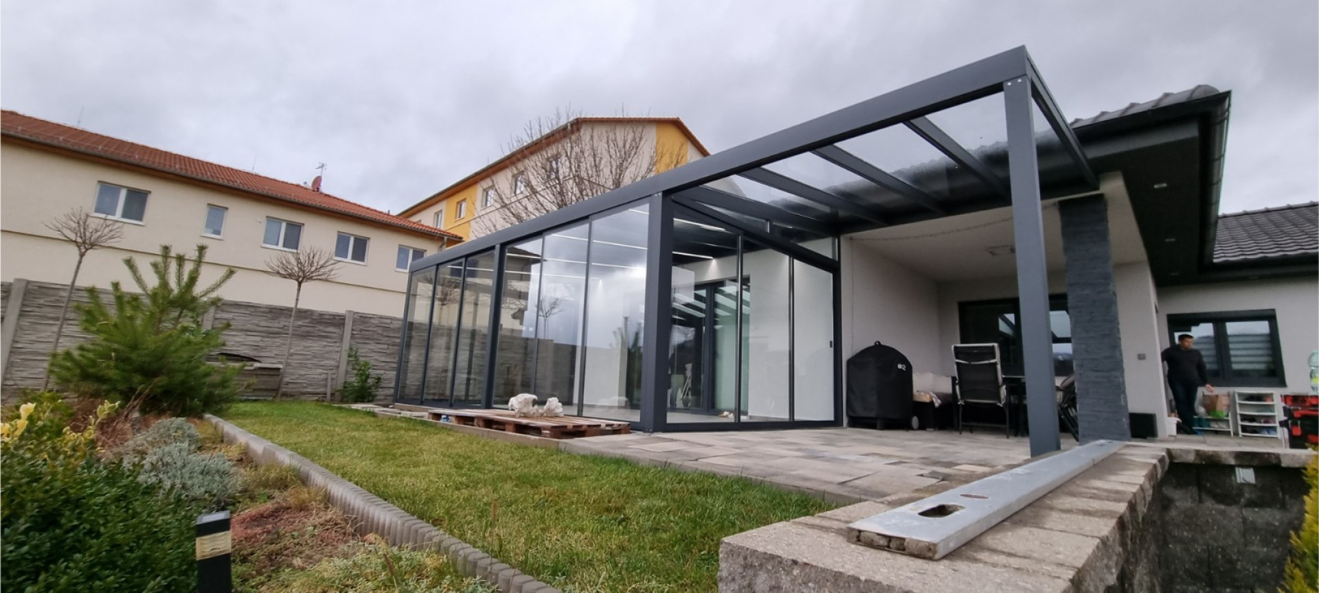 Moderní prosklená hliníková pergola s antracitovou konstrukcí postavená u rodinného domu v Klášterci.