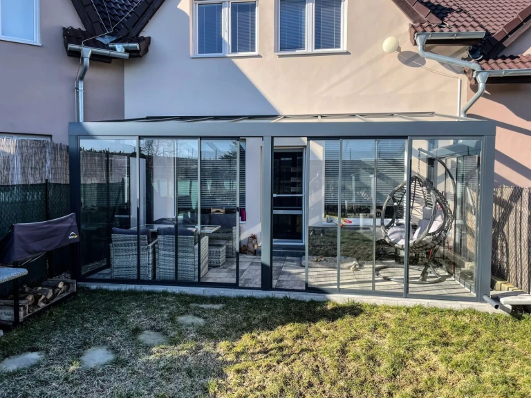 Moderní hliníková pergola ROBUST se standardním zasklením a zahradním nábytkem v obci Stehelčeves