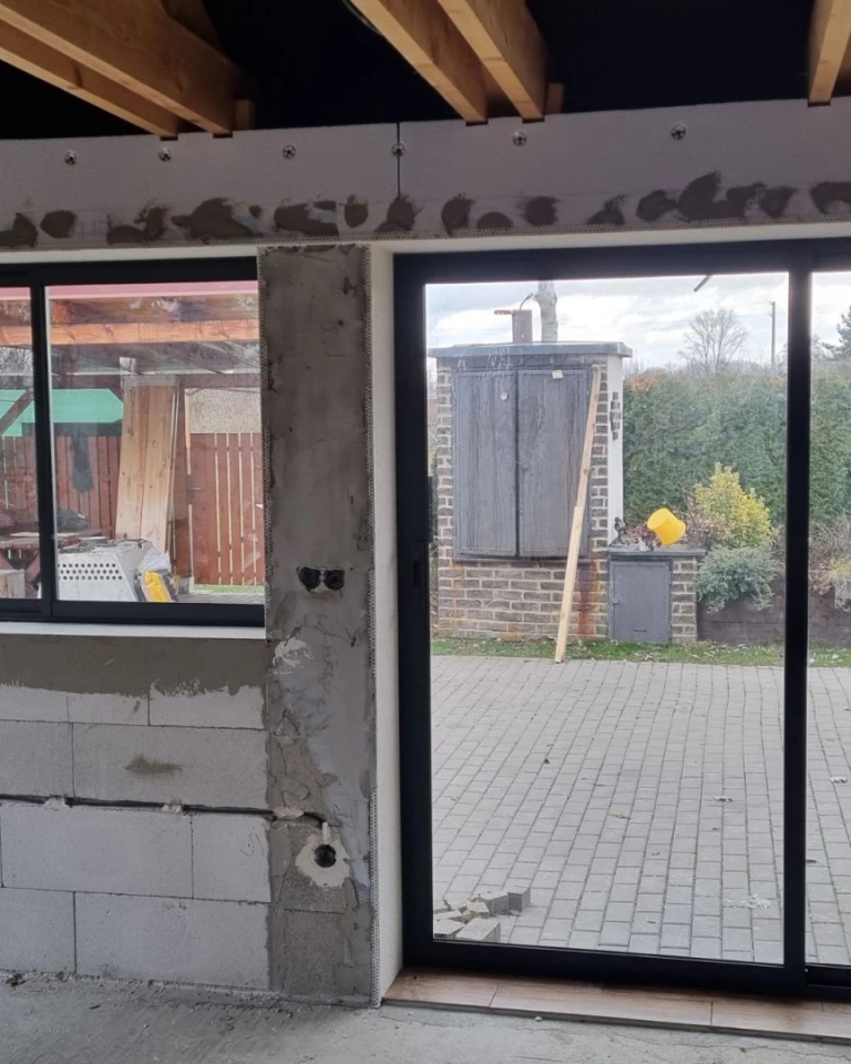 Terasa ve výstavbě s nainstalovaným hliníkovým zasklením Robust a výhledem do exteriéru
