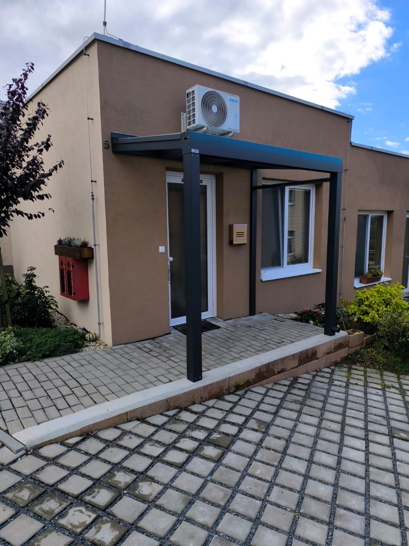 Moderní hliníková konstrukce nad vstupními dveřmi rodinného domu
