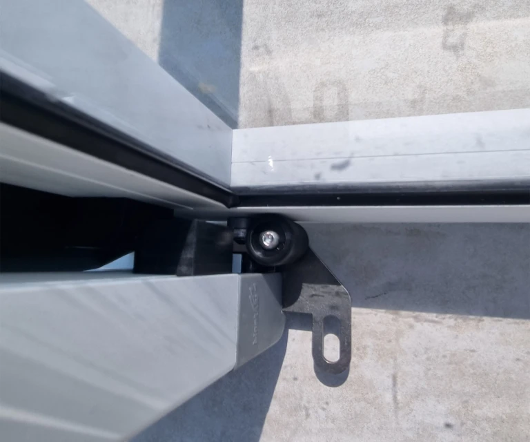Detailní pohled na vodicí mechanismus a kolečko bezkolejového zastřešení bazénu